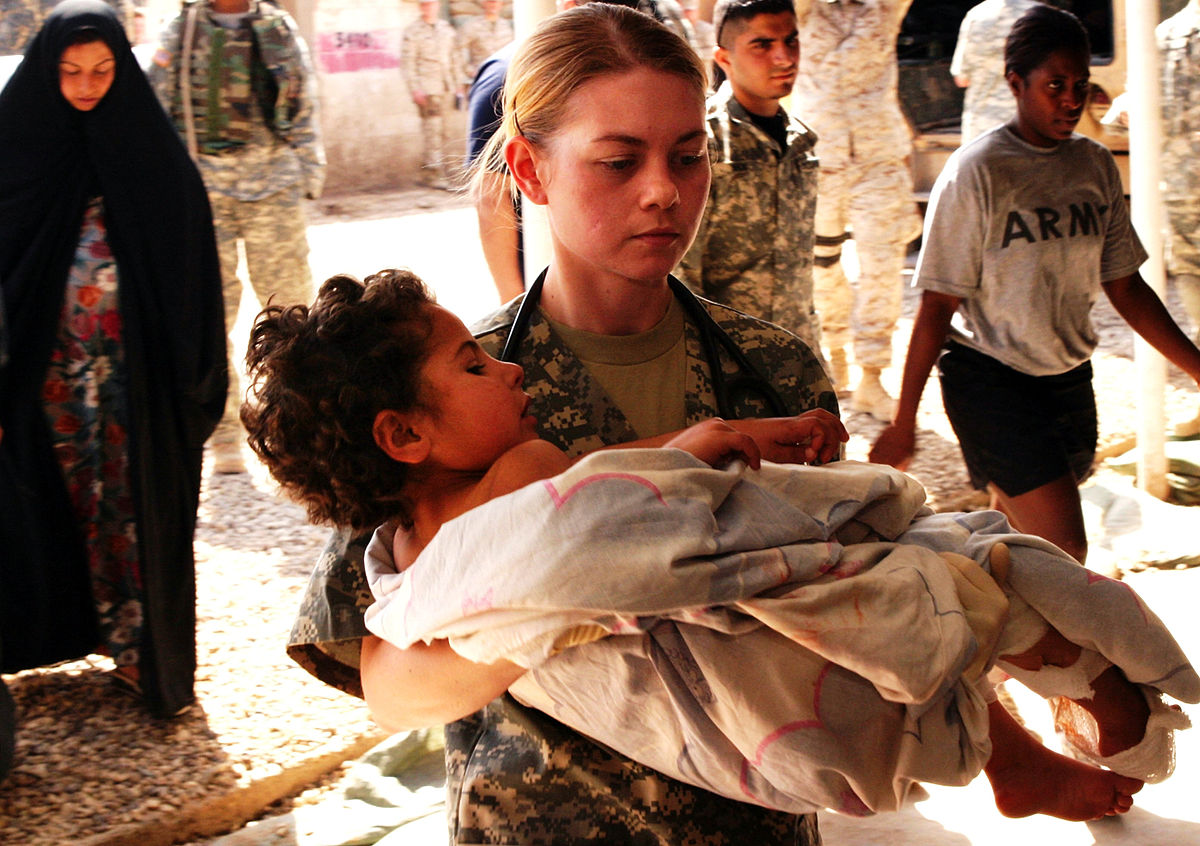 on the picture you see a Soldier carries a child